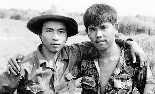 Nghệ sĩ nhiếp ảnh Chu Chí Thành trầm tư bên cuốn sách ảnh Ký ức chiến tranh của mình.