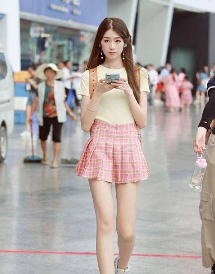 Gái xinh mặc váy ngắn xếp ly màu hồng khoe dáng trên phố