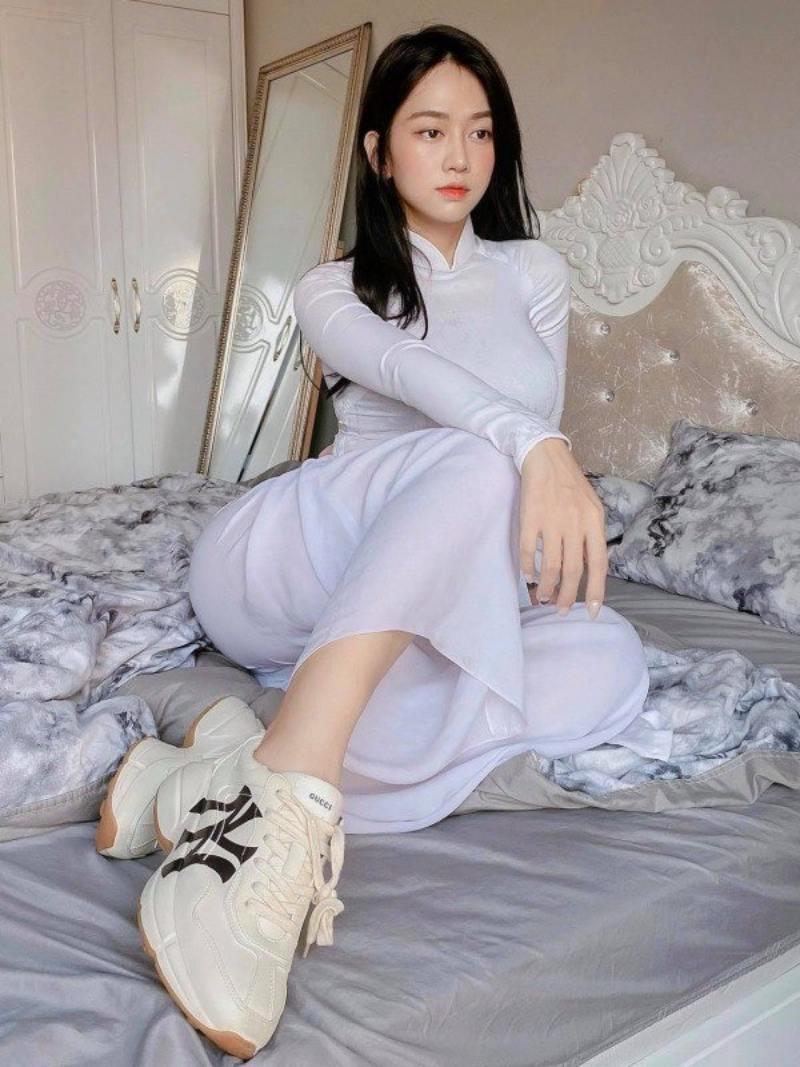 Ảnh Lê Bống mặc áo dài ngồi trên giường