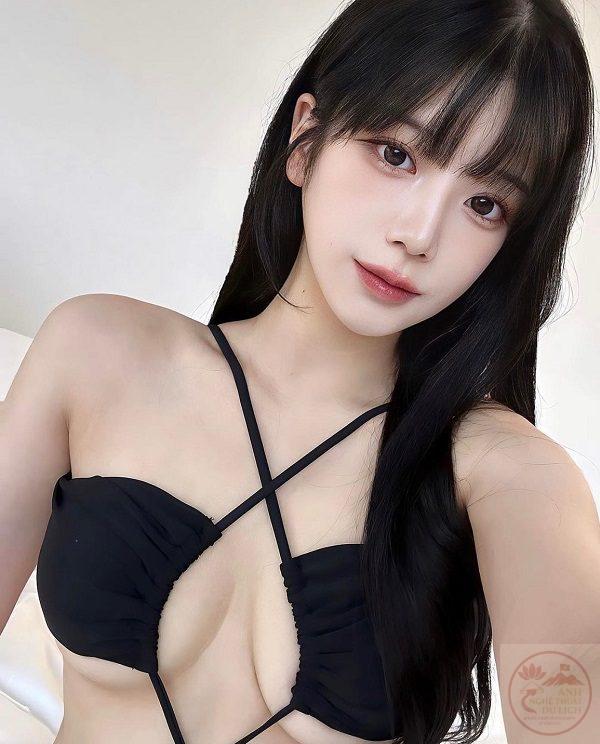 Gái xinh mặc bikini ngồi trên sàn gỗ trong phòng