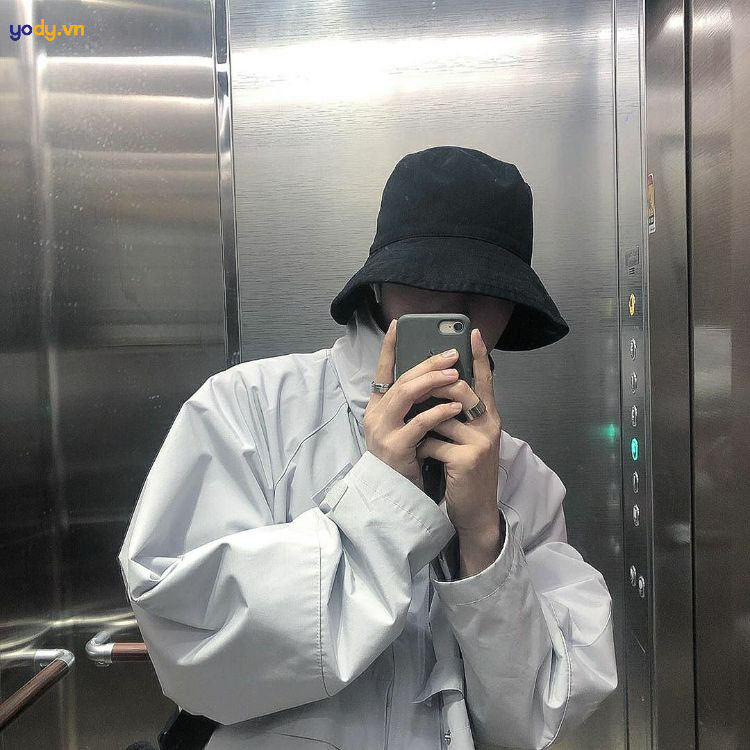 chàng trai che mặt ngồi ghế với mũ