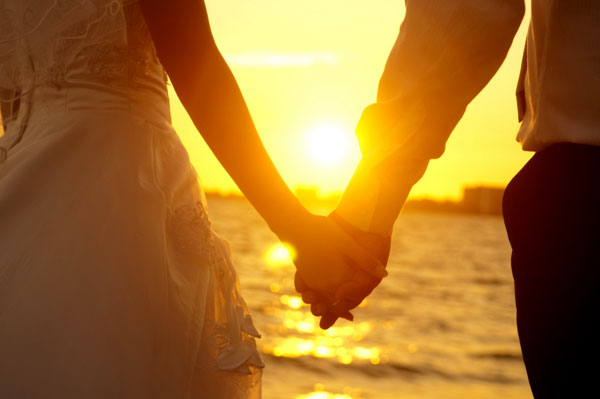 ảnh hai người nắm tay nhau trong chiều hoàng hôn bên bờ biển